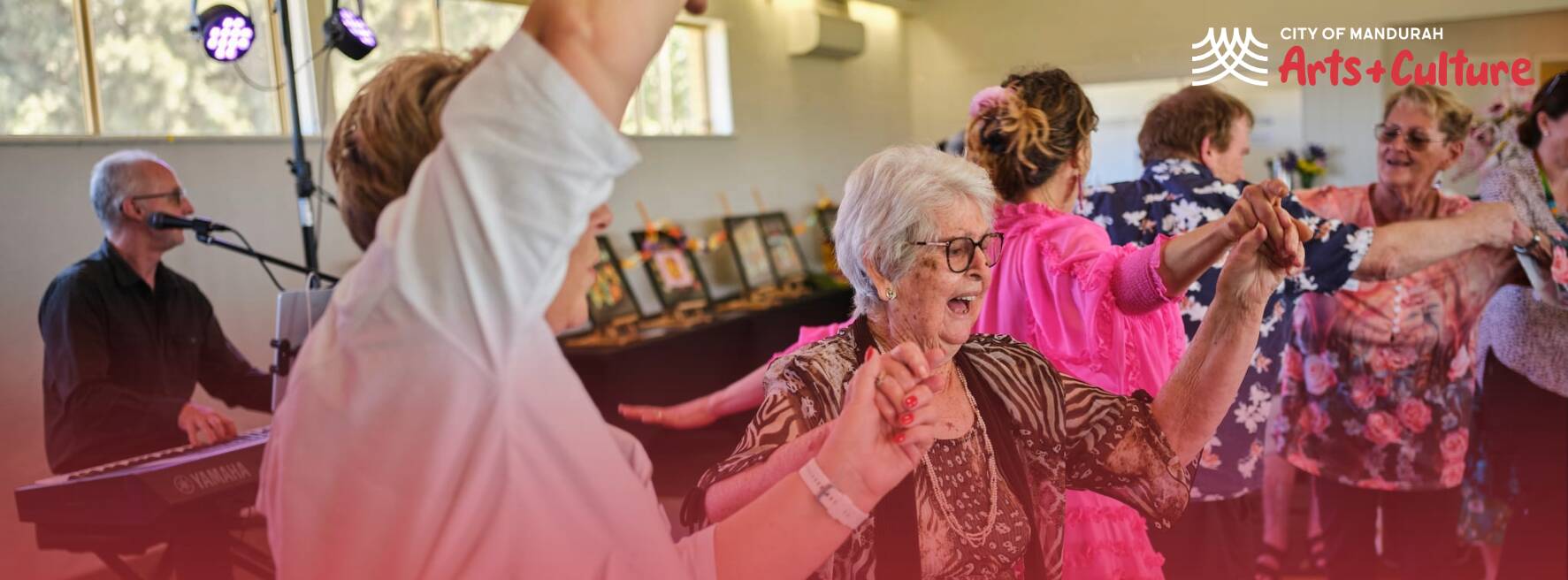 People dancing together in a bright room during a social arts activity.